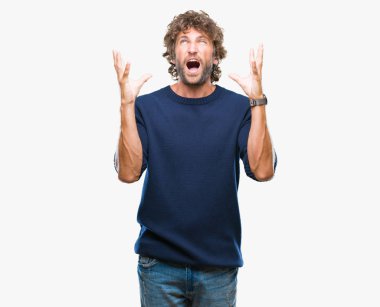 Yakışıklı İspanyol izole arka plan deli üzerinde kış kazak giyen adam model ve deli bağırarak ve agresif ifade ve silah kaldırdı bağırıyor. Hayal kırıklığı kavramı.