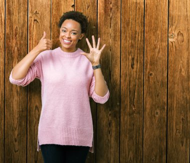 Güzel genç Afro-Amerikan kadın gösterilen ve parmakları ile işaret izole arka plan yüzünden kendinden emin ve mutlu gülümseyerek süre 6 numara.