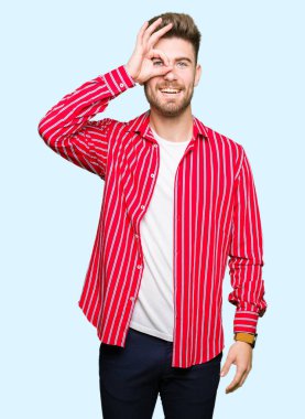 Genç yakışıklı giyen kırmızı gömlek gülümseyen, parmakları ile mutlu yüz üzerinden seyir göz el ile ok jest yapıyor adam.