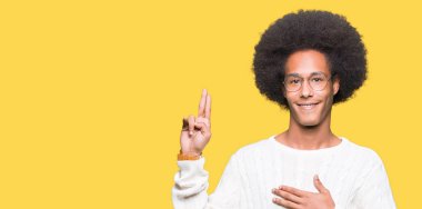 Afro saç giyen ile genç Afro-Amerikan adam Swearing göğüs ve parmaklar, el ile bir sadakat sözü yemin yapma gözlük
