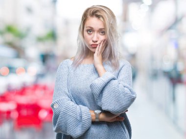 Seyir yorgun ve bıkkın ile depresyon sorun Çapraz kollar ile izole arka plan düşünme üzerinde kış kazak giyen genç sarışın kadın.