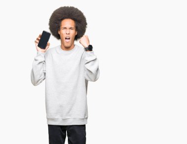 Afrikalı-Amerikalı genç afro saç gösteren smartphone ile ekran ile öfke, çılgın ve yükseltilmiş eliyle diye bağıran rahatsız ve hayal kırıklığına uğramış öfke kavramı bağırarak