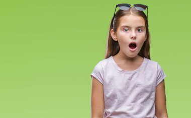 Genç güzel kız korkuyor ve şok sürpriz ifade, korku ve heyecan yüz ile izole arka plan üzerinde güneş gözlüğü takıyor.