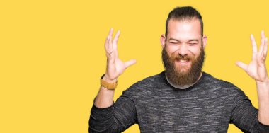 Kızgın ve silah ile başarı için deli rahat kazak kutluyor giyen genç sarışın adam kaldırdı ve heyecanlı çığlık gözler kapalı. Kazanan kavramı