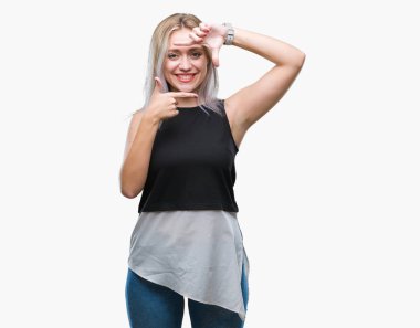 Genç Sarışın kadın elle yapma çerçeve ve parmakları ile mutlu yüz gülümseyen izole arka plan yüzünden. Yaratıcılık ve Fotoğrafçılık kavramı.