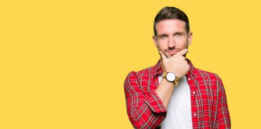 Yakışıklı adam rahat gömlek emin çapraz kollar ve çeneme kaldırdı el ile gülümseme ile kameraya bakıyor. Pozitif düşünce.