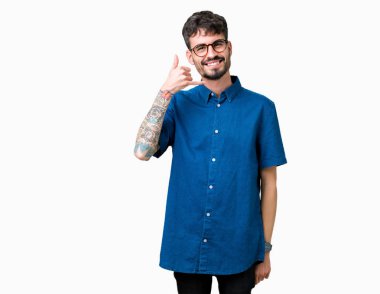 Yakışıklı delikanlı yapıyor gülümseyen izole arka plan üzerinde gözlük telefon hareketi ile el ve parmak telefonda konuşuyor gibi. Kavramları iletişim.