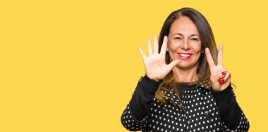 Gösterilen ve parmakları ile işaret güzel orta yaş kadın giyiyor moda ceket kendinden emin ve mutlu gülümseyerek süre yedi numara.