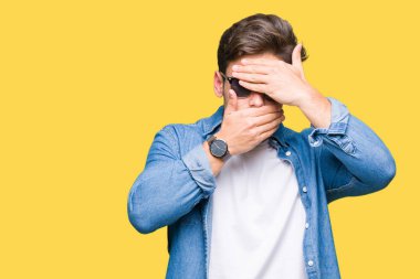 Yakışıklı delikanlı izole arka plan kaplaması gözler ve ağız el ile üzerinde güneş gözlüğü takıyor şaşırttı ve şok. Duygu gizleme