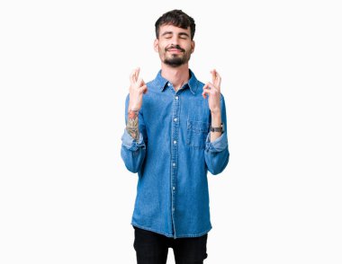 Yakışıklı delikanlı geçiş parmakları umut ve gözleri kapalı ile gülümseyen izole arka plan üzerinde. Şans ve batıl kavramı.