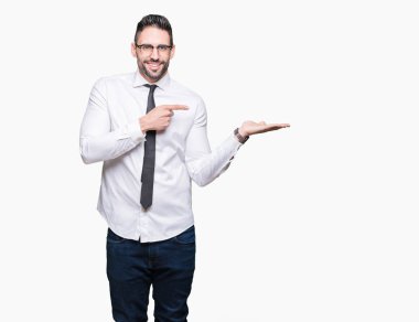 Hayret ve el ile sunulması ve parmak ile işaret ederken kameraya gülümseyen izole arka plan üzerinde gözlük takan genç yakışıklı iş adamı.