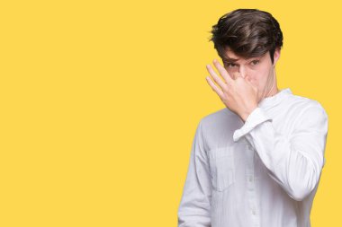 Genç yakışıklı iş adamı izole arka plan bir şey pis ve iğrenç kokulu, dayanılmaz koku, holding nefes burun parmaklar ile. Kötü kokuyor kavramı.