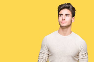 Yakışıklı delikanlı görünümlü yan ve dik dik bakma uzağa düşünce gülümseyen izole arka plan üzerinde.