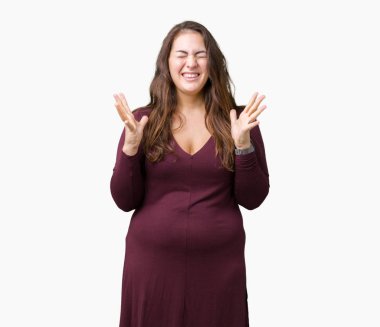 Güzel ve çekici artı boyutu genç kadın izole arka plan kutlama üzerinde bir elbiseyle deli ve crazy arms ile başarı için kaldırdı ve heyecanlı çığlık gözler kapalı. Kazanan kavramı