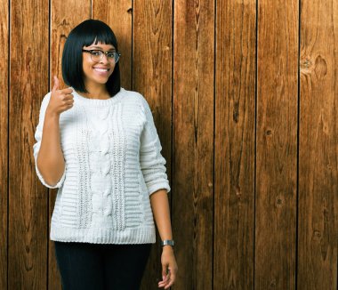 Güzel genç Afro-Amerikan kadın hareketi el ile mutlu yaşasın yapıyor izole arka plan üzerinde gözlük takıyorum. Başarı gösteren kameraya bakarak ifade onaylama.