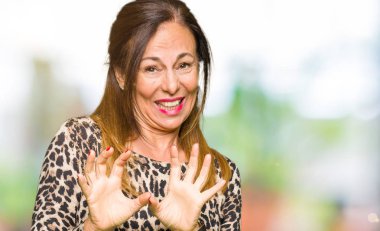 Leopar hayvan baskı elbise giyen güzel orta yaş kadın tiksinti ifadesi, memnun ve korkulu tiksinti yüz yapıyorsun çünkü nefret tepki. Elleriyle kaldırdı. Sinir bozucu kavramı.