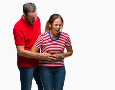 Orta yaş İspanyol çift aşık ile izole arka plan üzerinde elini karnına çünkü mide bulantısı, ağrılı hastalık hasta hissediyor. Ağrısı kavramı.