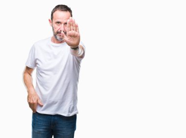 Orta yaş ağarmış komuta sizde dur yapıyor izole arka plan üzerinde beyaz t-shirt giyen elin avuç ile şarkı. Negatif ve ciddi bir jest yüz ifadesiyle uyarı.