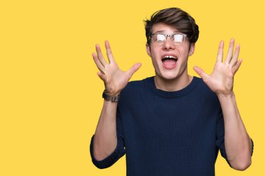 Üzerinde gözlük takan genç yakışıklı adam deli kutluyor arka plan izole ve silah ile başarı için yükseltilmiş ve açık gözleri heyecanlı çığlık hayrete düşürdü. Kazanan kavramı