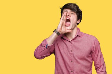 Genç yakışıklı iş adamı bağırarak ve ağzı üzerinde el ile yan için çığlık izole arka plan üzerinde. İletişim kavramı.