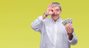 Yakışıklı komuta sizde para demet mutlu yüz el parmaklarının arasından seyir göz üzerinde ok işaretiyle yapıyor gülümseyen izole arka plan üzerinde tutan