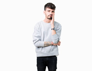 Seyir yorgun ve bıkkın ile depresyon sorun Çapraz kollar ile izole arka plan düşünme üzerinde sweatshirt giyen genç yakışıklı adam.