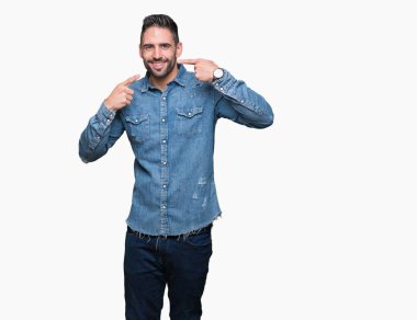 Tecrit edilmiş, güler yüzlü, kendine güvenen, parmaklarını, dişlerini ve ağzını gösteren genç yakışıklı bir adam. Sağlık kavramı.