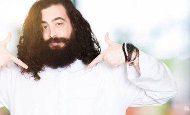 Yüzünde gülümseme ile kendinden emin görünüyorsun, kendini gururlu ve mutlu parmakları ile işaret giyen İsa Mesih kostüm adamım.