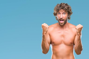 Yakışıklı İspanyol modeli adam seksi ve izole arka plan kutlama içinde gömleksiz şaşırttı ve başarı için kaldırdı kollarını açarak hayret ve gözleri açık. Kazanan kavramı.