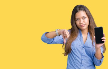 Genç güzel esmer iş kadın gösteren ekran smartphone kızgın yüzü, eksi işareti aşağı antipati başparmak ile gösterilen, ret kavramı ile izole arka plan üzerinde