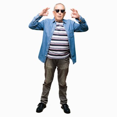 Yakışıklı komuta sizde giyen denim ceket ve güneş gözlüğü dinlenmek ve gülümseyen gözlerle kapalı parmak jestle meditasyon yapıyor. Yoga kavramı.