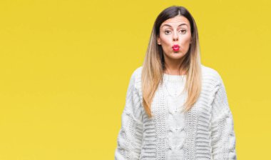 Genç güzel kadın komik surat ile yanakları şişirme izole arka plan üzerinde rahat beyaz kazak. Ağız ile hava, deli ifade şişirilmiş.