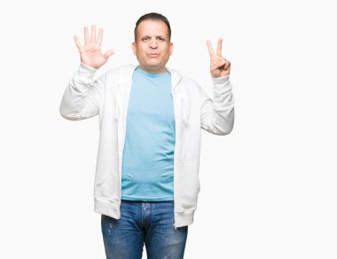 Gösterilen arka plan üzerinde sweatshirt giyen orta yaş Arap adam izole ve parmakları ile işaret kendinden emin ve mutlu gülümseyerek süre yedi numara.