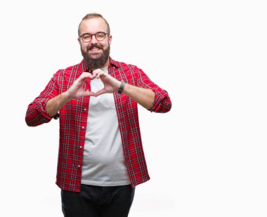 Kalp simgesi ve elleriyle şekil gösterilen aşık gülümseyen izole arka plan üzerinde gözlük takan Genç beyaz hipster adam. Romantik kavramı.