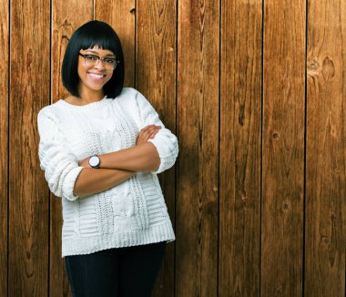 Güzel genç Afro-Amerikan kadın üzerine gözlük ile mutlu yüz gülümseyerek kameraya seyir silah geçti arka plan izole. Olumlu bir kişi.