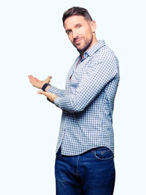 Açık el ile doğal gülümseyen girmek için davet mavi gözlü yakışıklı iş adamı