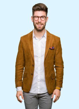 Seksi bir ifadeyle, neşeli ve mutlu yüzünü kameraya bakarak göz kırpıyor genç yakışıklı iş adam gözlük.