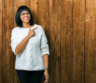 Güzel genç Afro-Amerikan kadın izole arka neşeli bir gülümseme ile yüz el ve parmak kadar mutlu ve doğal ifade yüzünde yanında işaret içinde gözlük