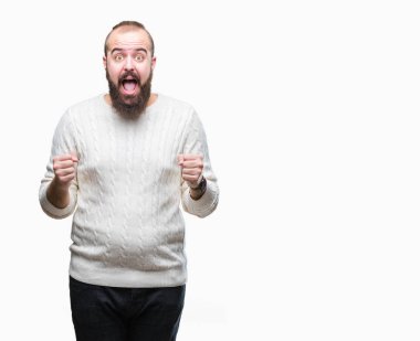 İzole arka plan kutlama üzerinde giyen kış kazak şaşırttı ve silah ile başarı için hayran Genç beyaz hipster adam kaldırdı ve gözleri açık. Kazanan kavramı.