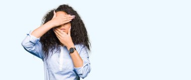 Kıvırcık saçlı gözlük kapsayan gözler ve ağız el ile giyen genç güzel iş kız şaşırttı ve şok. Duygu gizleme