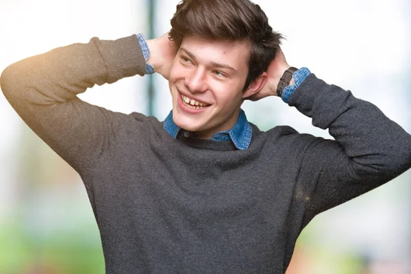 Young handsome elegant man over isolated background Relaxing and stretching with arms and hands behind head and neck, smiling happy