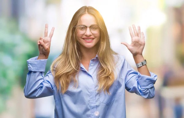 Young beautiful blonde business woman wearing glasses over isolated background showing and pointing up with fingers number seven while smiling confident and happy.