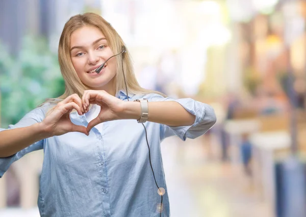 年轻的白种人商业妇女佩戴呼叫中心耳机在孤立的背景微笑的爱显示心脏符号和形状与手 浪漫概念 — 图库照片