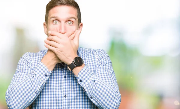 Hata için ellerle ağız kapsayan şok mavi gözlü yakışıklı iş adamı. Gizli kavramı.