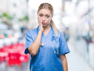 Genç Sarışın cerrah doktor kadın yorgun ve bıkkın ile depresyon sorun Çapraz kollar ile seyir düşünüyorum izole arka plan.