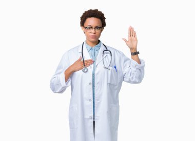 Üzerinde tıbbi ceket giyen genç Afro-Amerikan doktor kadın izole arka plan göğüs ve bir sadakat sözü yemin yapma avuç, el ile küfür
