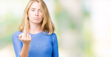 İzole arka plan gösteren orta parmak, kaba ve kaba siktir git ifade üzerinde mavi kazak giyen güzel genç kadın