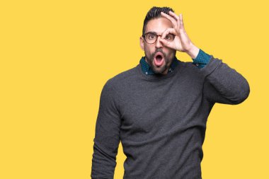 Sürpriz yüz, göz parmaklarının arasından seyir ile ok jest yapıyor izole arka plan üzerinde gözlüklü genç yakışıklı adam şok. İmansız ifade.