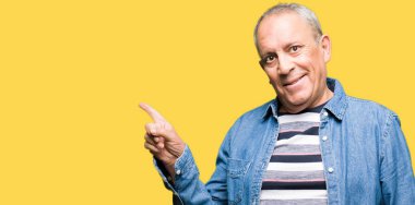 Kameraya bakarak yan el ve parmak ile işaret eden yakışıklı komuta sizde Kot ceket kocaman bir gülümseme ile yüzünde,.