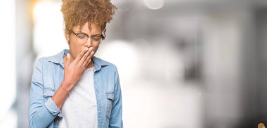 Güzel genç Afro-Amerikan kadın izole arka plan üzerinde gözlük el ağzıyla kapsayan yorgun esneme sıkılmış. Restless ve uyku hali.